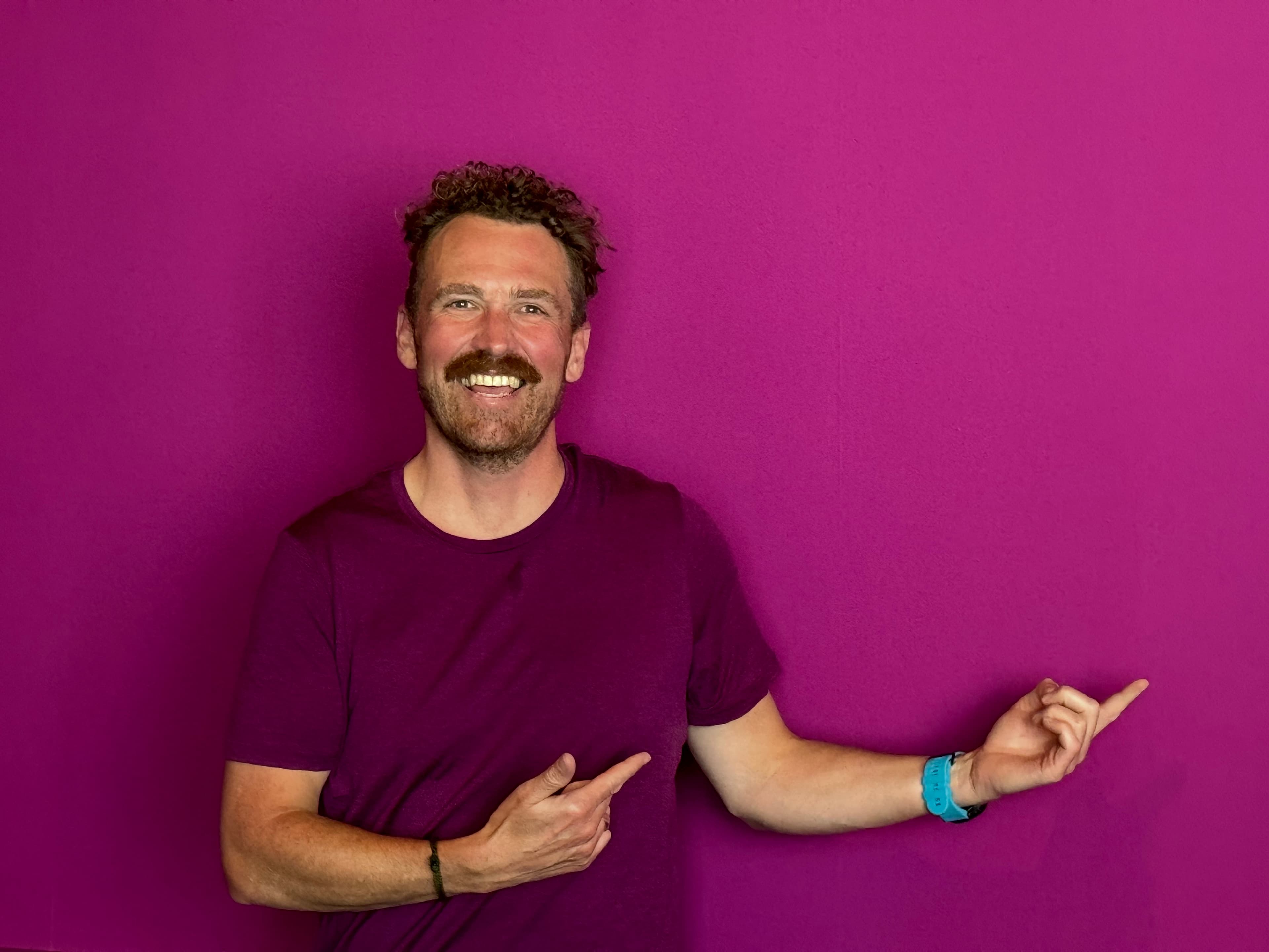 Trent Mankelow, founder of Electric Interview, pointing toward the Electric Interview name